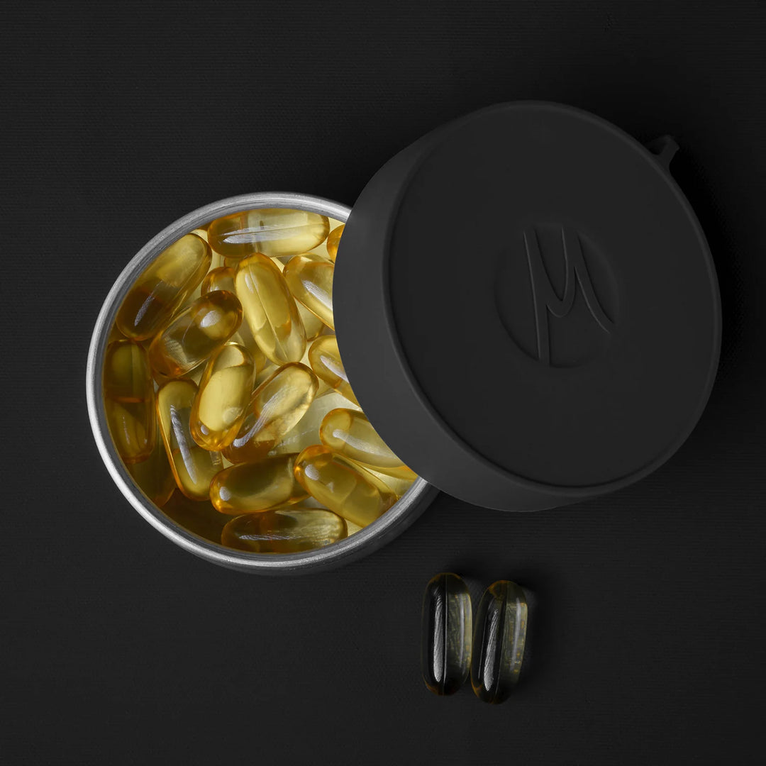 Large canister full of fish oil pills on black background
