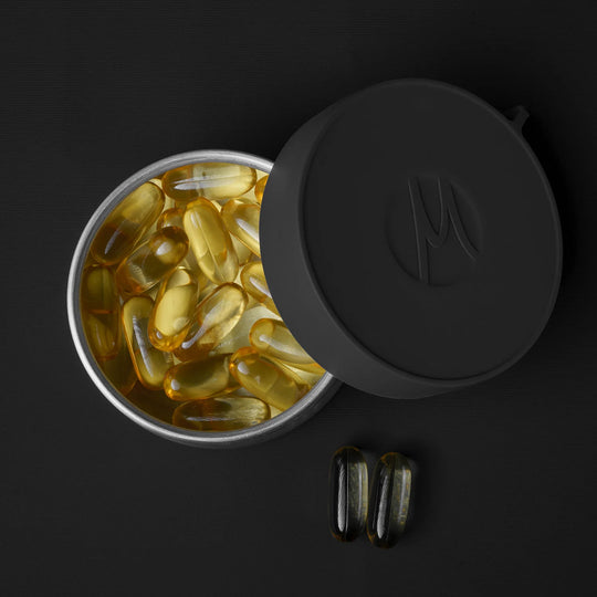 Large canister full of fish oil pills on black background