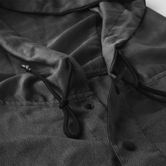 Close up view of charcoal poncho details including hood pull stings and snap button collar
