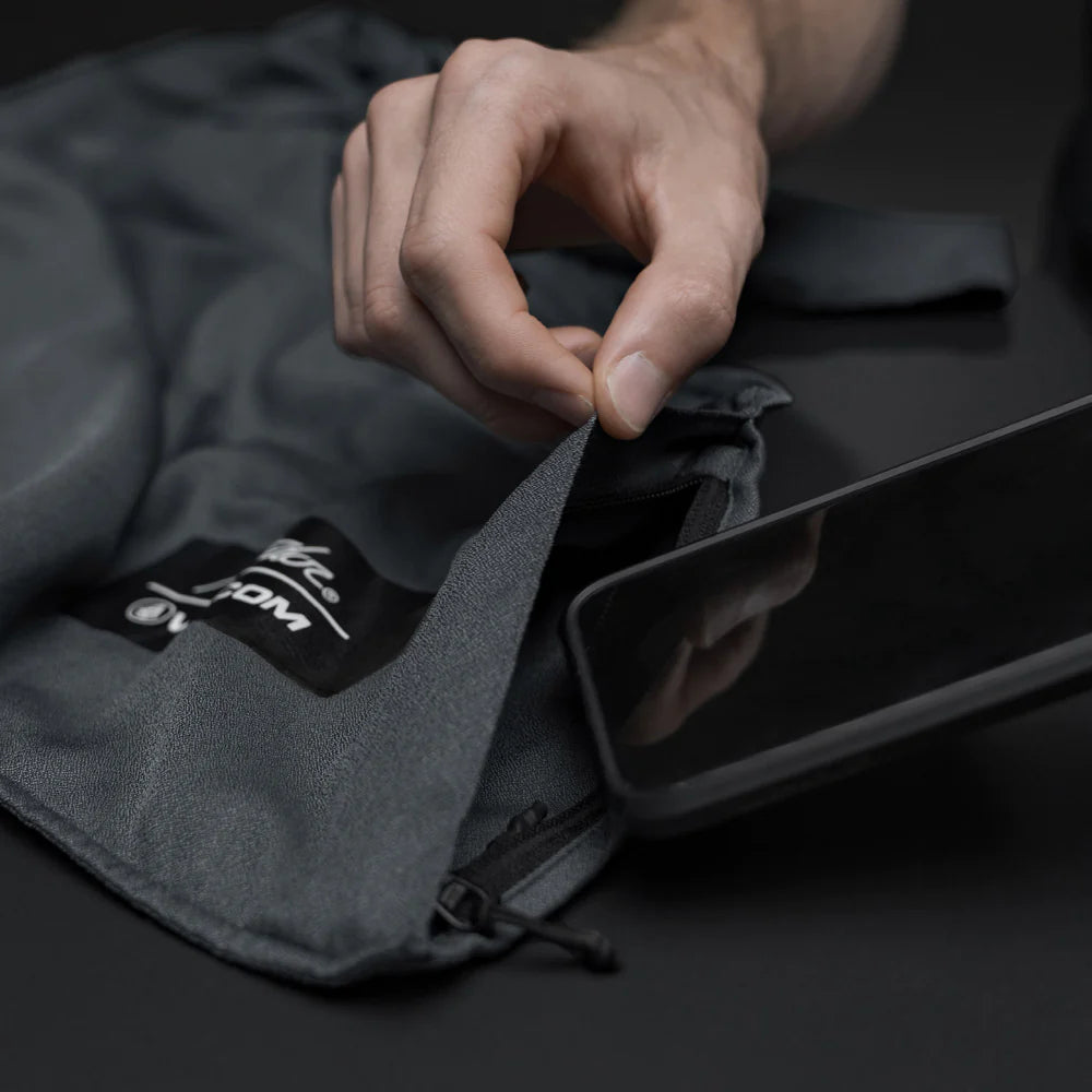 close up studio photo of cell phone being placed in charcoal beach towel pocket