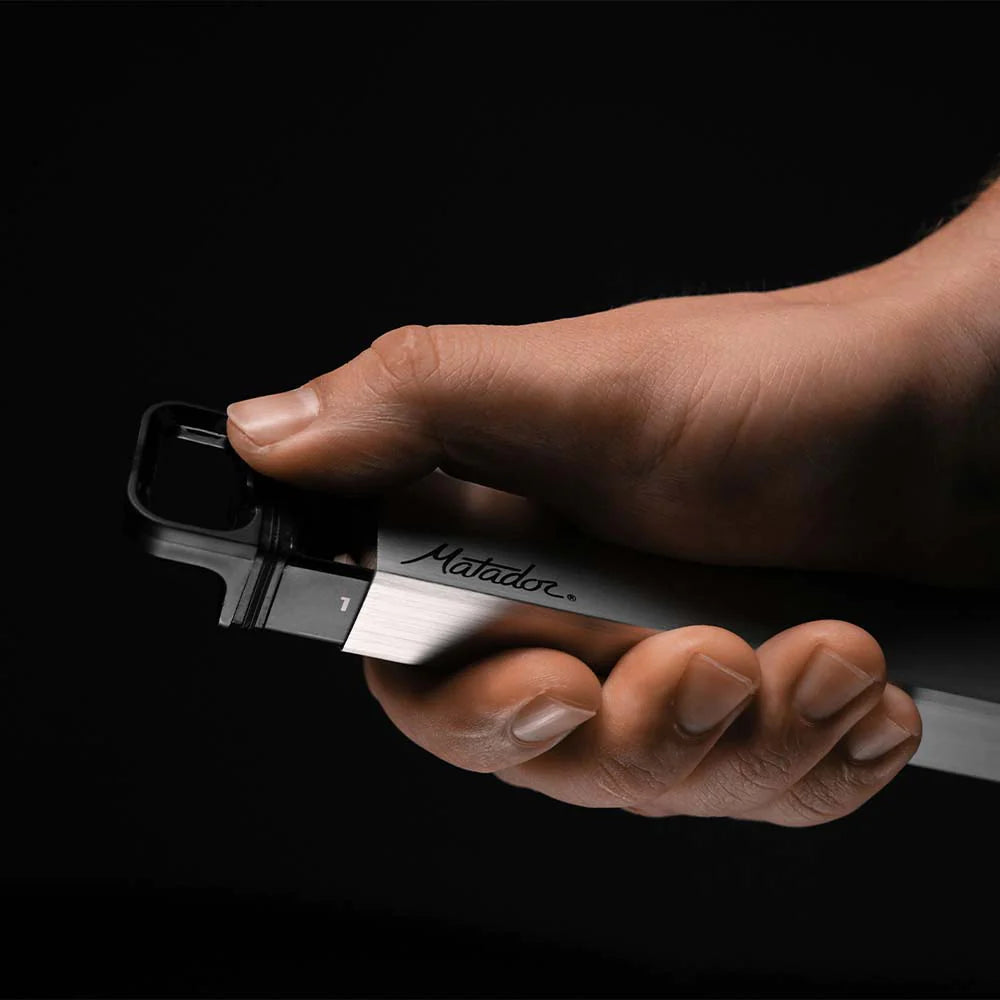 Thumb pushing open pill canister on black background