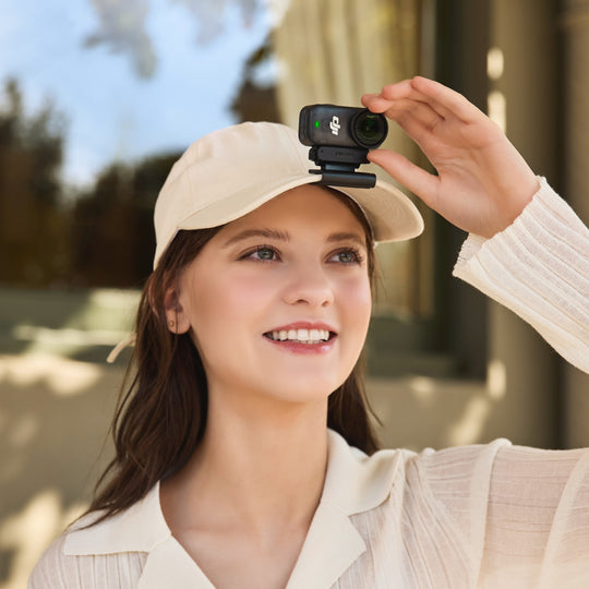 Woman holding a camera with a microphone attachment outdoors