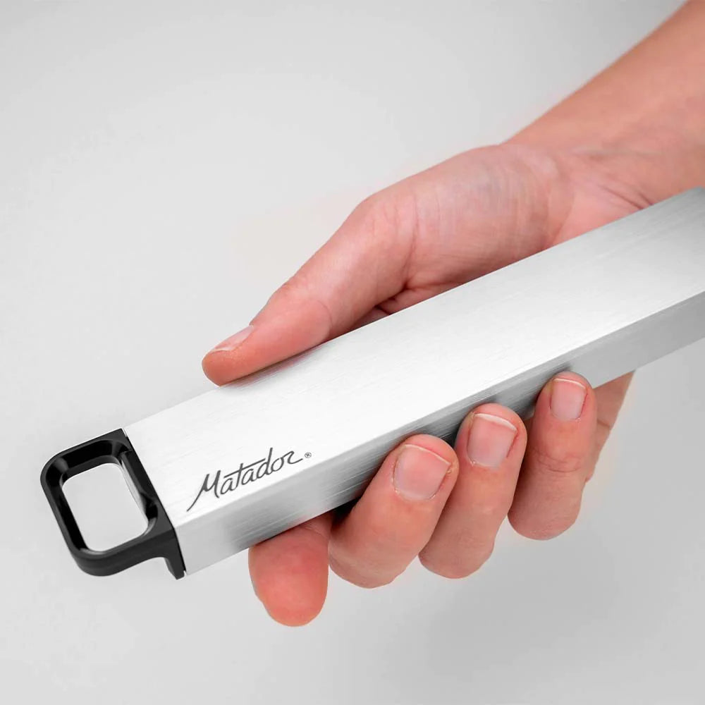 Hand holding pill canister on gray background