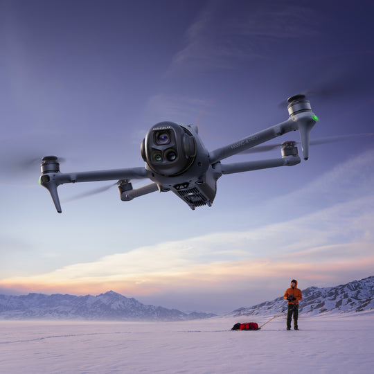 DJI Mavic 4 Pro Drone flying over a snowy landscape with a person in the background