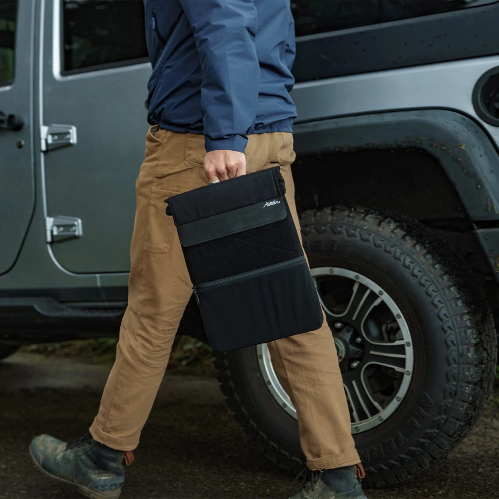 Man walking outside holding Laptop base layer by cary handle