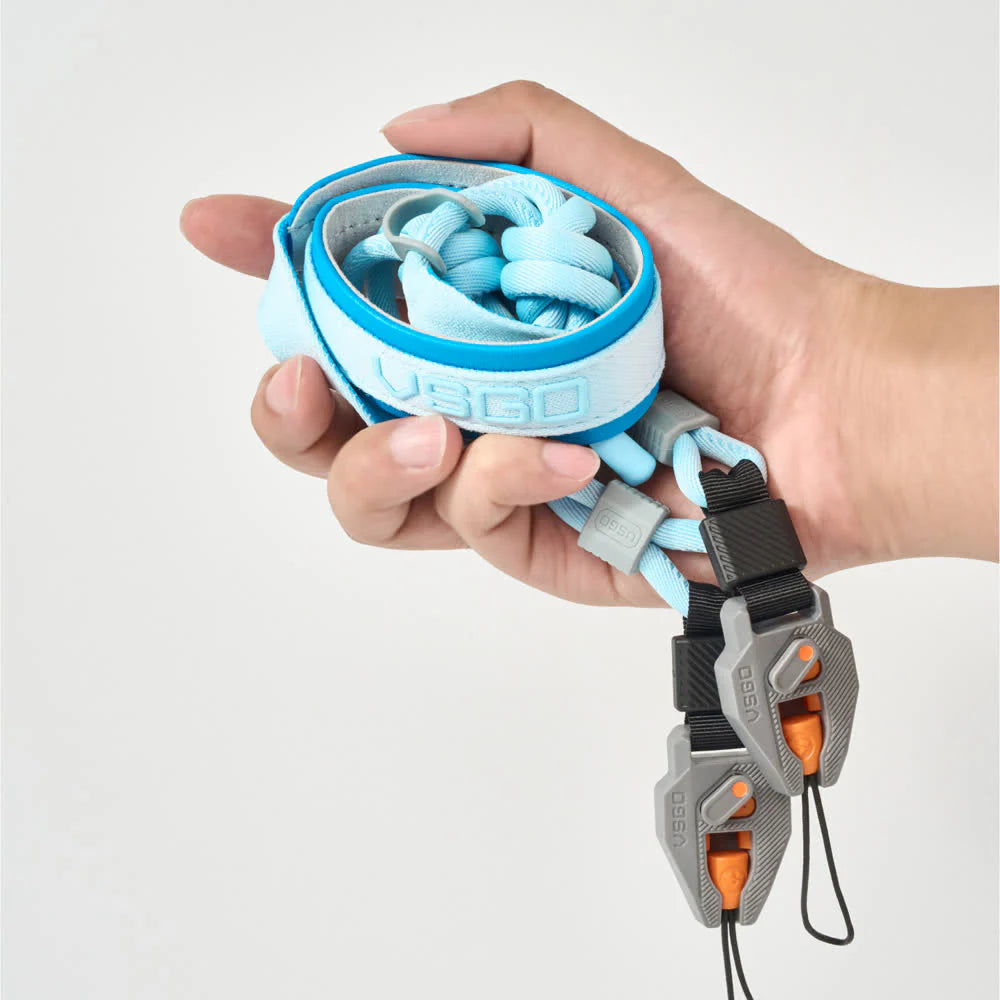 Hand holding VSGO Black Snipe CASUAL Camera Strap on a white background