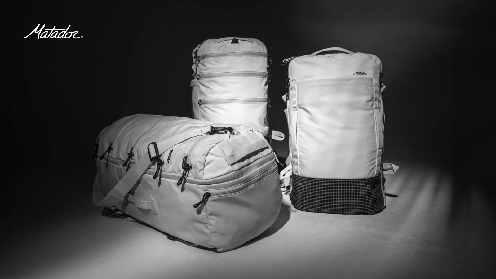 Three Matador backpacks on a dark background