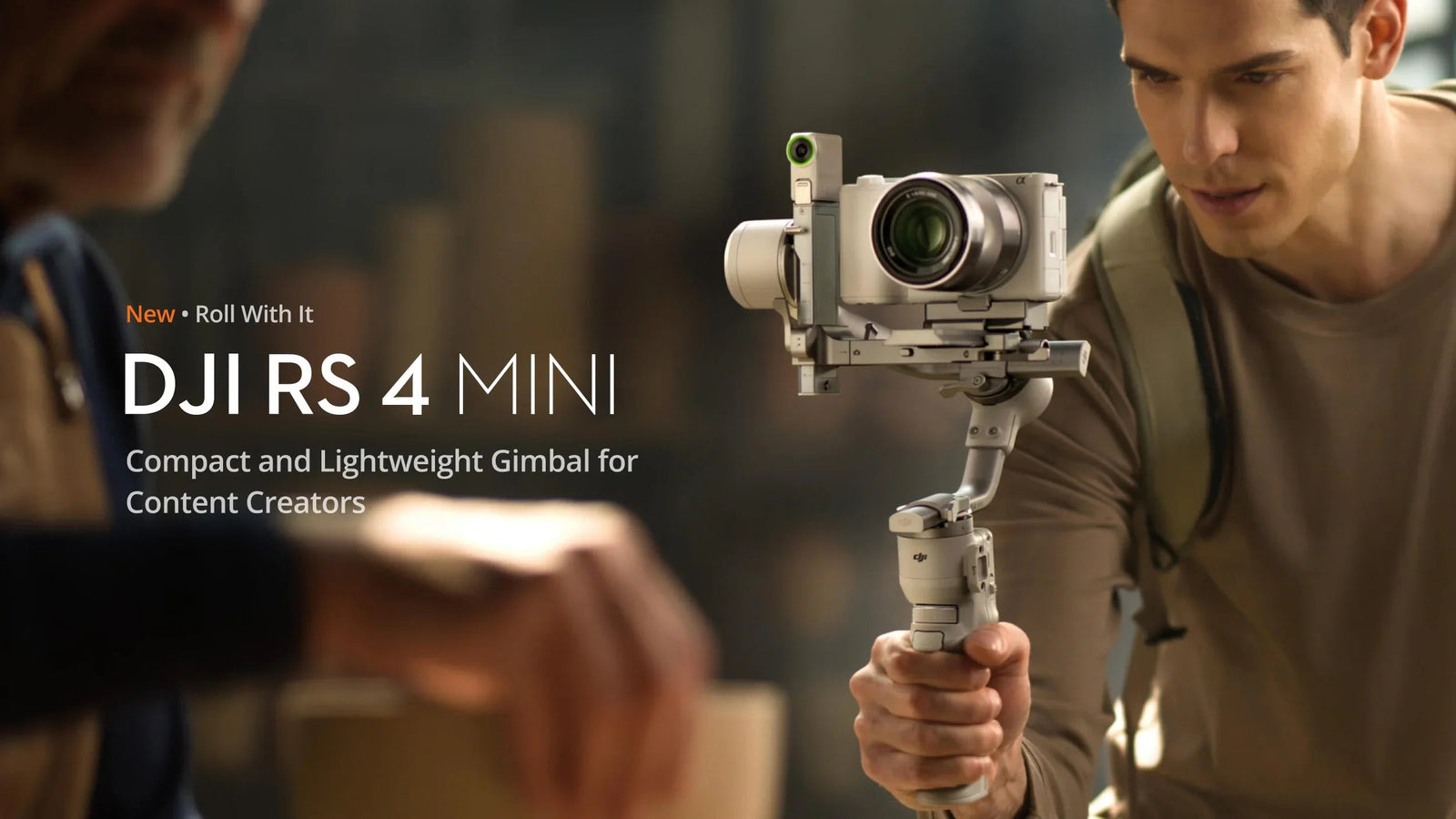 Man holding DJI RS 4 Mini compact gimbal stabilizer with camera, ideal for content creators