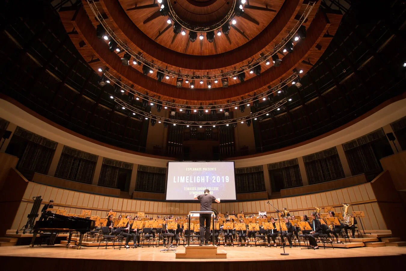 Orchestra with conductor performing on stage in a modern concert hall, Limelight 2019 event.