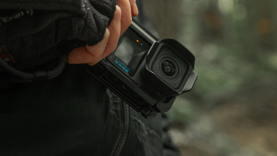 Person holding a Gopro Mission 1 black action camera with a blurred background