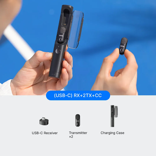 Hands holding wireless microphone transmitter and receiver with charging case on a blue background