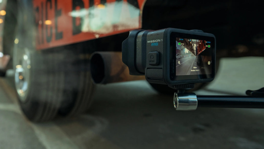 Action camera mounted on a vehicle's exhaust pipe with a blurred background