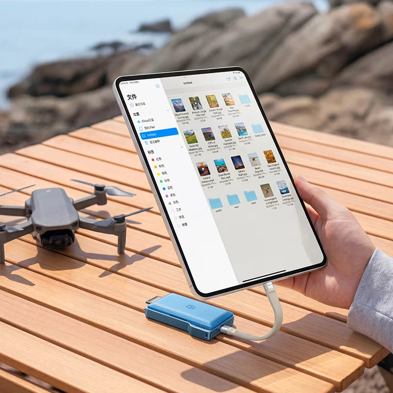 Person using a tablet app on a wooden table with a drone nearby