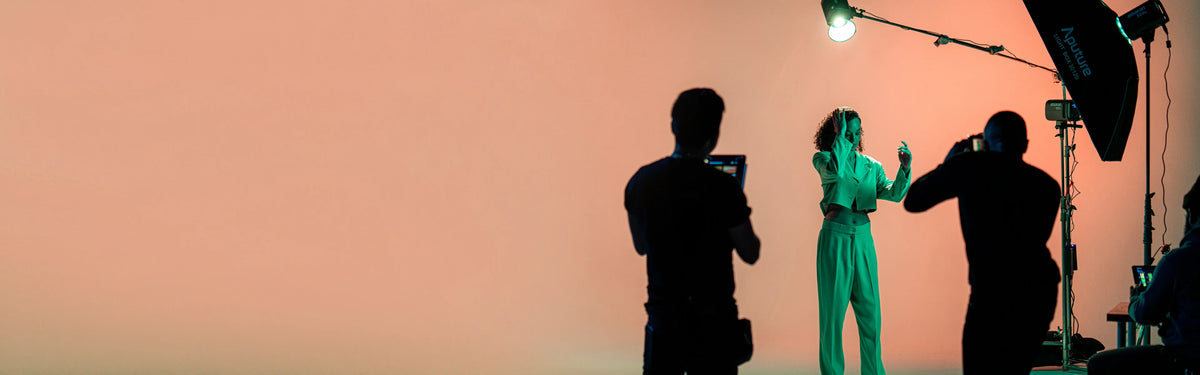 Silhouettes of people on a film set with a pinkish-orange background