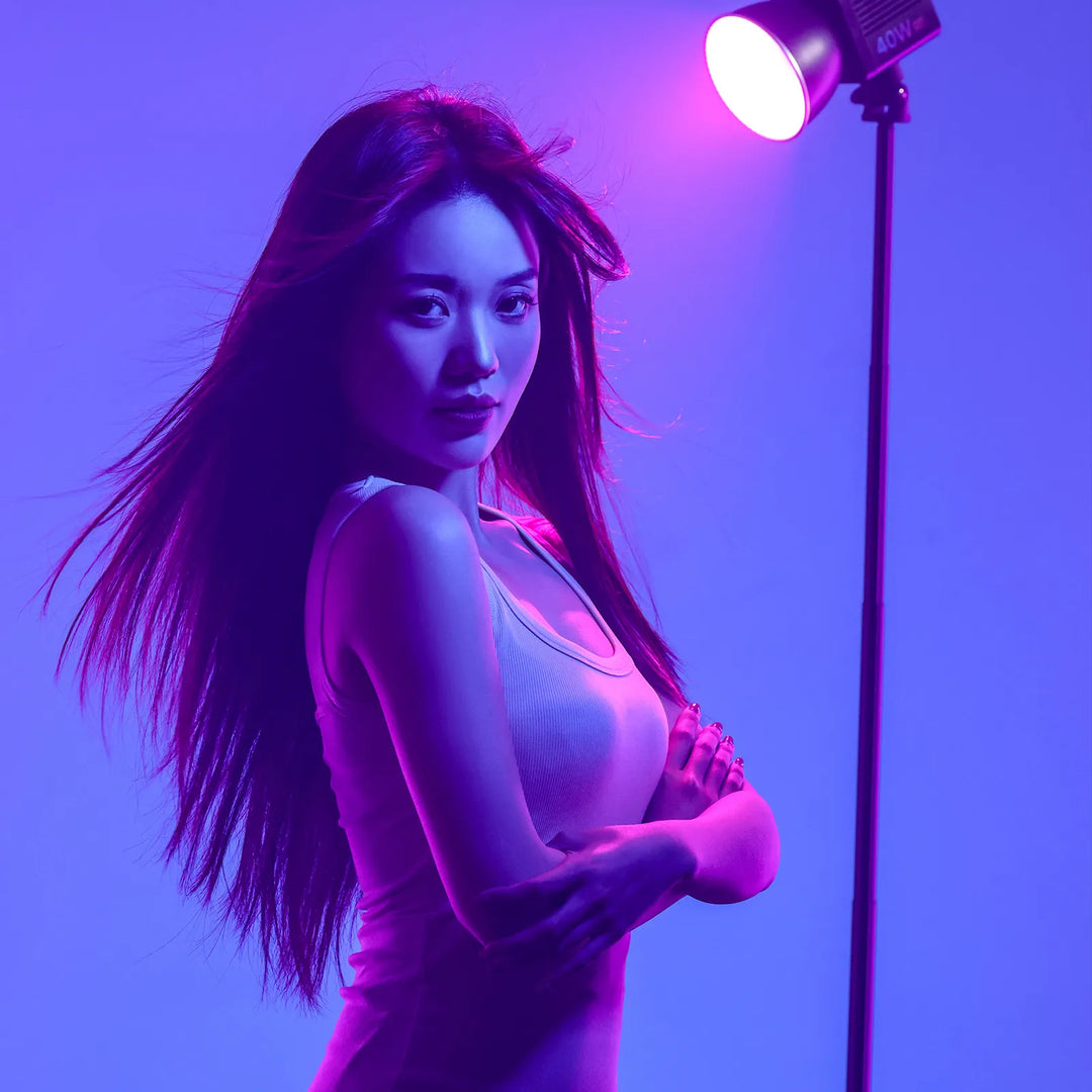 Woman in a white dress standing in front of a purple light