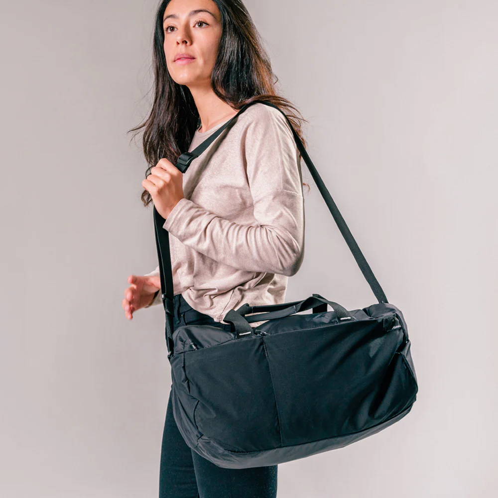 A girl carring Matador ReFraction Packable Duffle bag