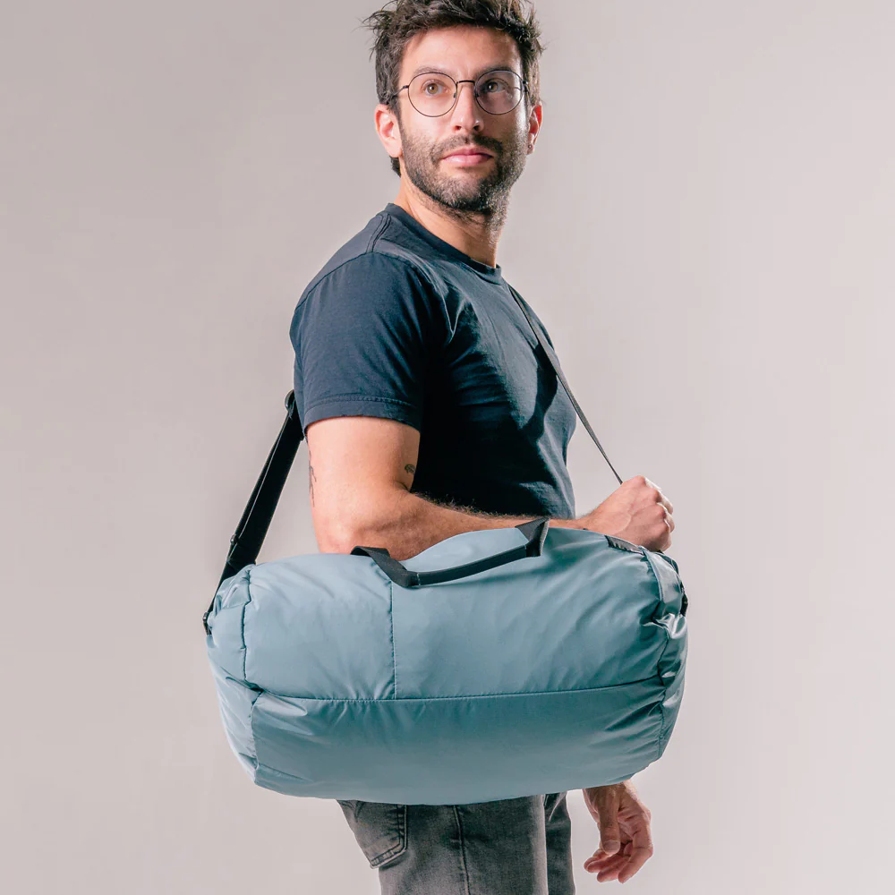 A male model carring Matador ReFraction Packable Duffle bag