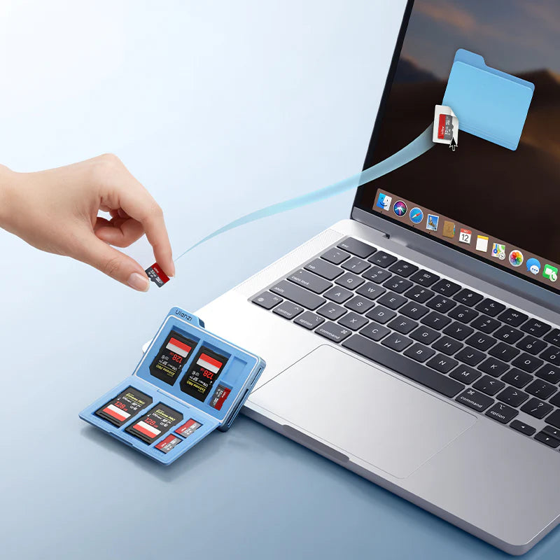 Hand inserting an SD card into a laptop with a blue background