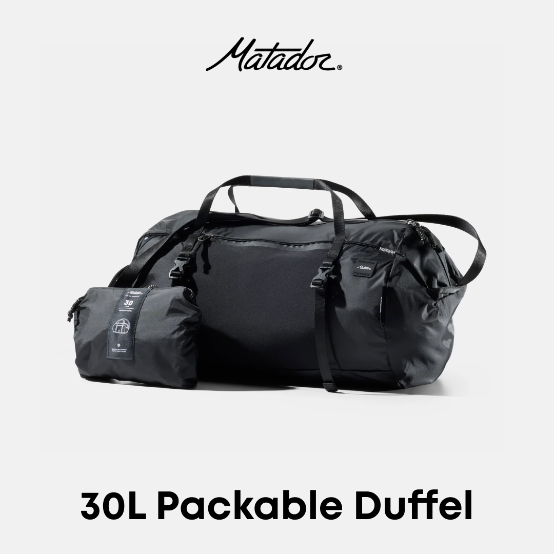 A black Matador 30L packable duffel bag shown with its compact folded pouch beside it on a light gray background, with the Matador logo at the top and &