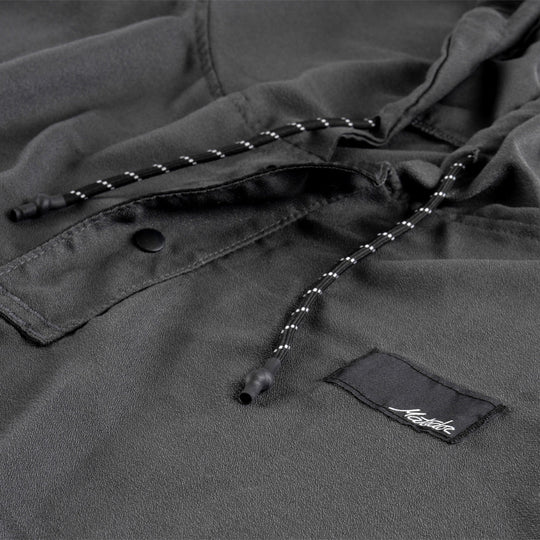 Close-up of a NanoDry Packable Towel Poncho with a brand label on a matching background