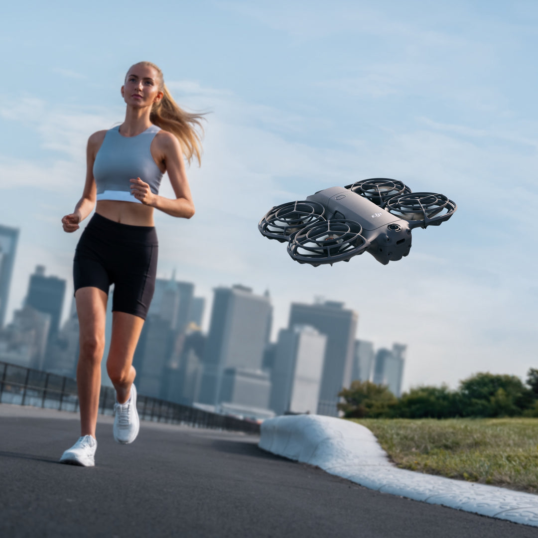 Woman running on a path with a drone flying above her in an urban setting