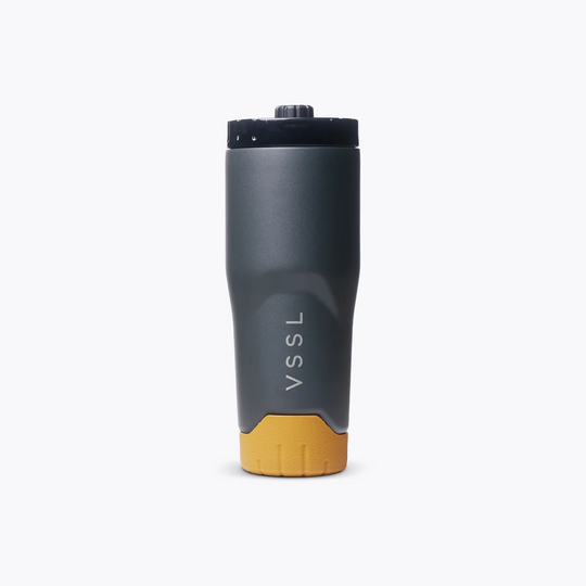 A VSSL insulated water bottle with a matte dark gray body, a mustard yellow base, and a black lid, shown on a clean white background.