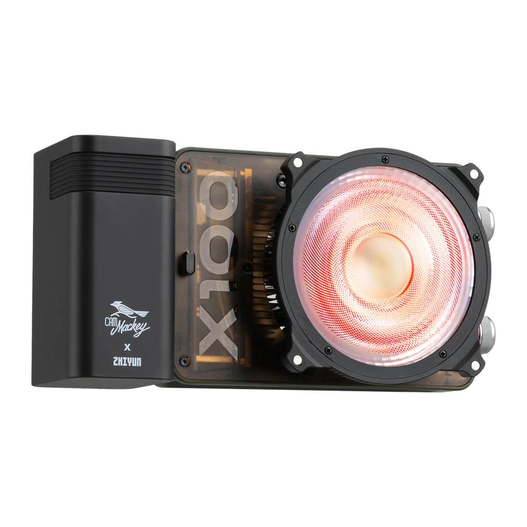 A black ZHIYUN MOLUS X100 RGB with a transparent side panel showing a gold CPU inside, featuring a large circular fan with a glowing red-orange light and a black side module with a white logo.