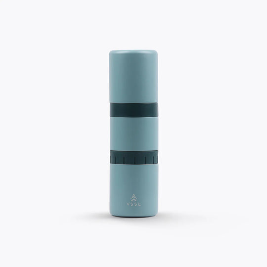 A light blue Nest Pour Over Coffee Kit with a dark teal band in the middle, featuring the VSSL logo near the bottom, set against a plain white background.