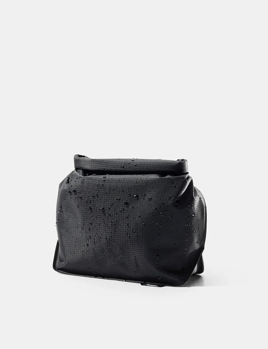 Black leather bag with studded details on a light gray background