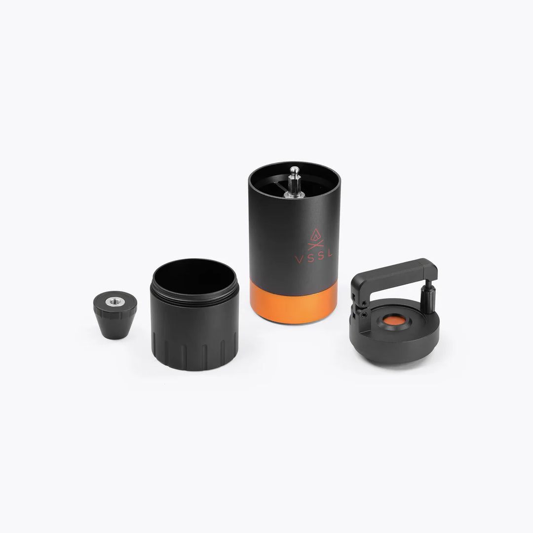 Black and orange coffee grinder with attachments on a white background