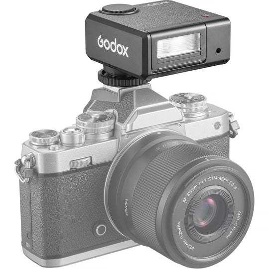 Camera with Godox iM30Pro Mini Flash attachment on a white background