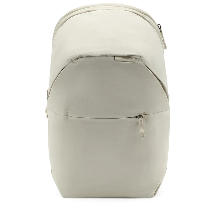 A light beige backpack with a front zippered pocket, shown from the back view against a plain white background.