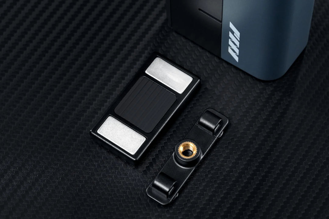 Black and silver electronic device with a strap on a textured black surface