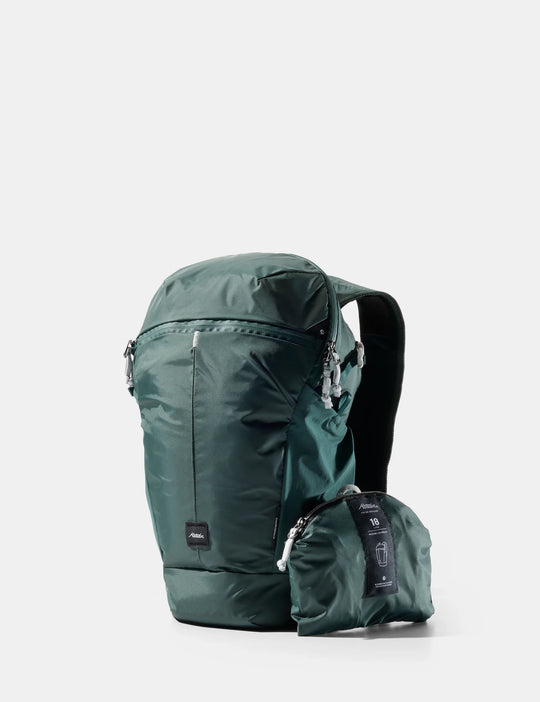 A dark green waterproof backpack shown next to its matching compact zippered carrying pouch on a light gray background.