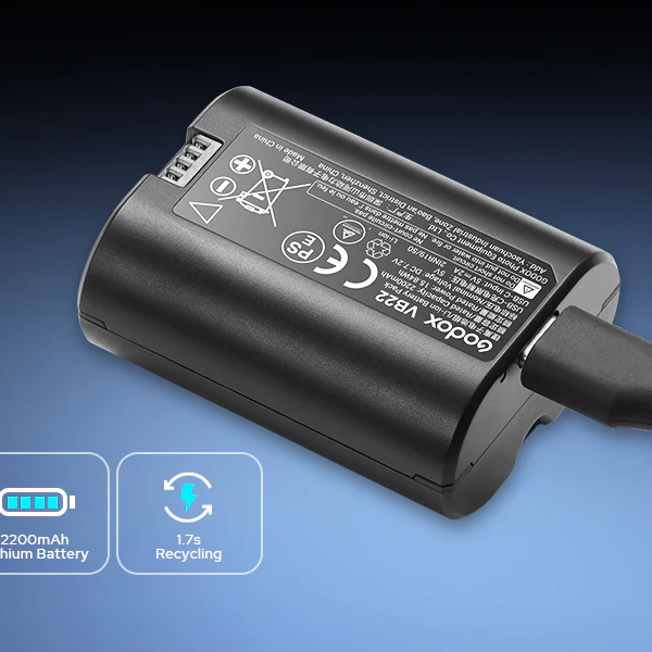 Black battery pack with charging cable on a blue gradient background
