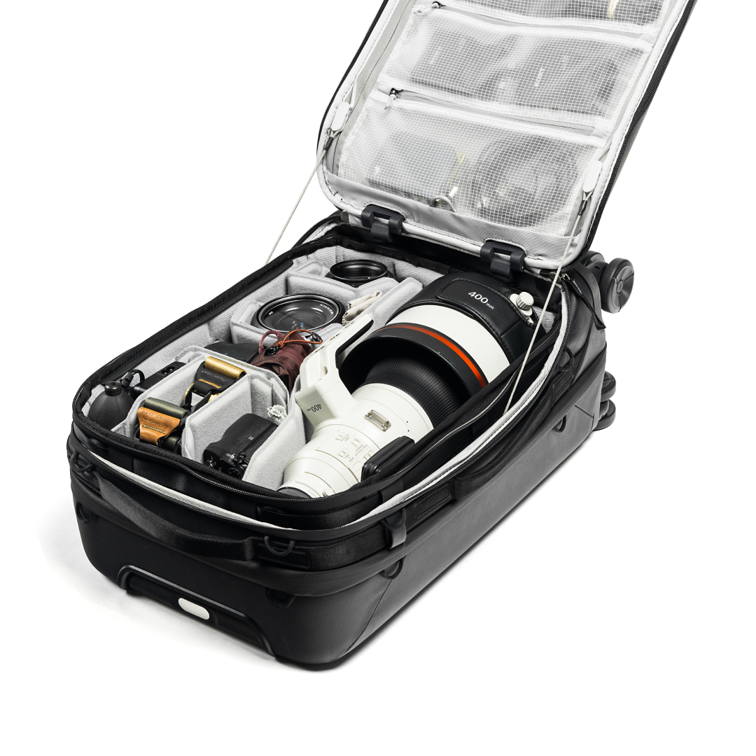 Camera equipment neatly packed inside a black suitcase on a white background
