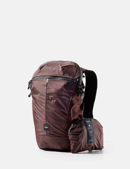 Brown backpack with a smaller pack attached on a white background