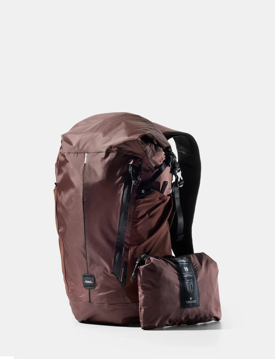 Brown backpack with a smaller pack attached on a white background