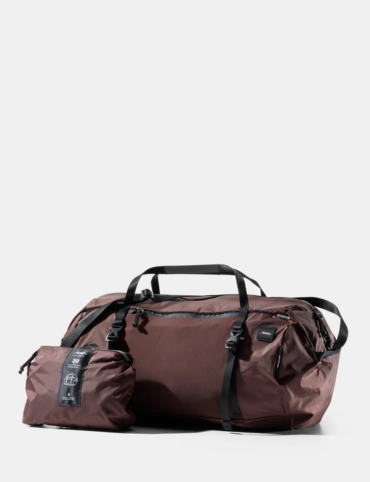Brown duffel bag with a smaller pouch on a white background