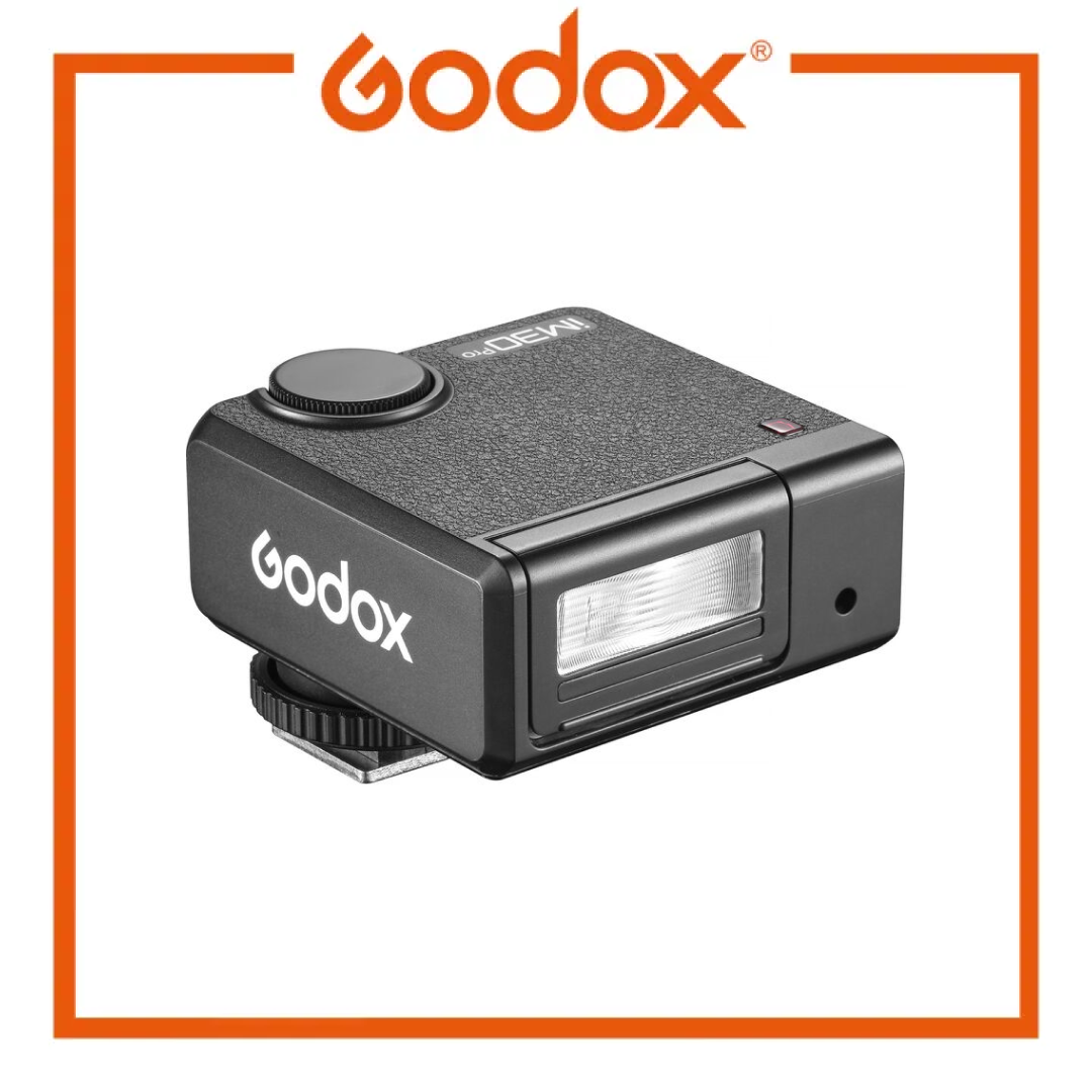 A Godox iM30Pro wireless camera flash modifier in black, featuring a textured top surface, a top dial, and a front lens window, shown on a white background with an orange Godox logo and border.