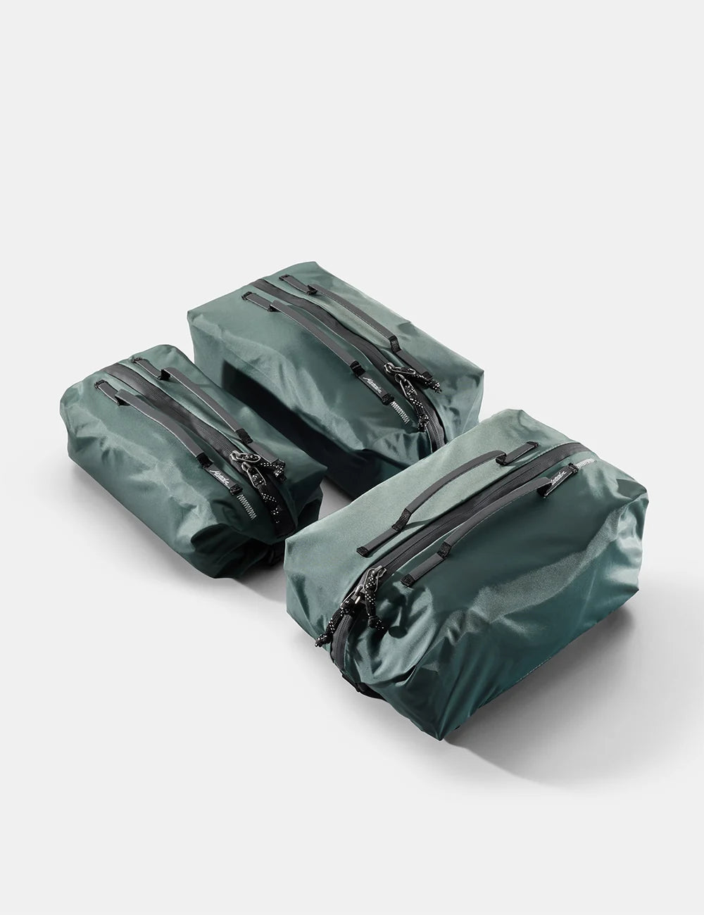 Three green waterproof bags with zippers on a white background