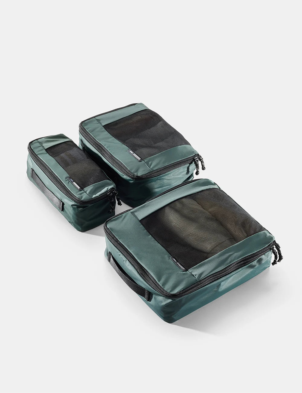 Set of green packing cubes on a white background