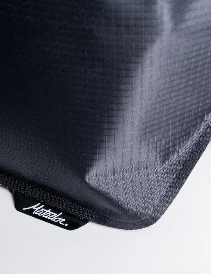 Close-up of a black textured bag with 'Matador' branding on a white background