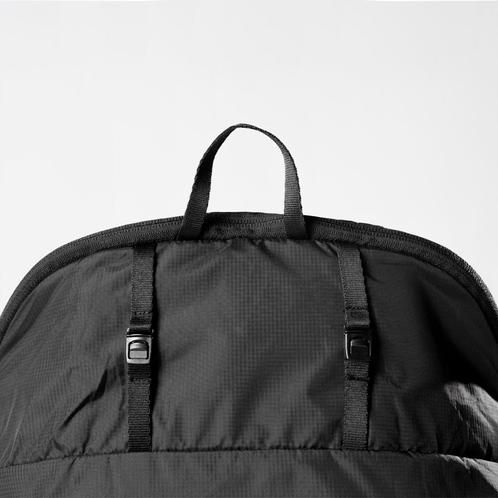 Black Packable Laundry Bag with straps on a light gray background