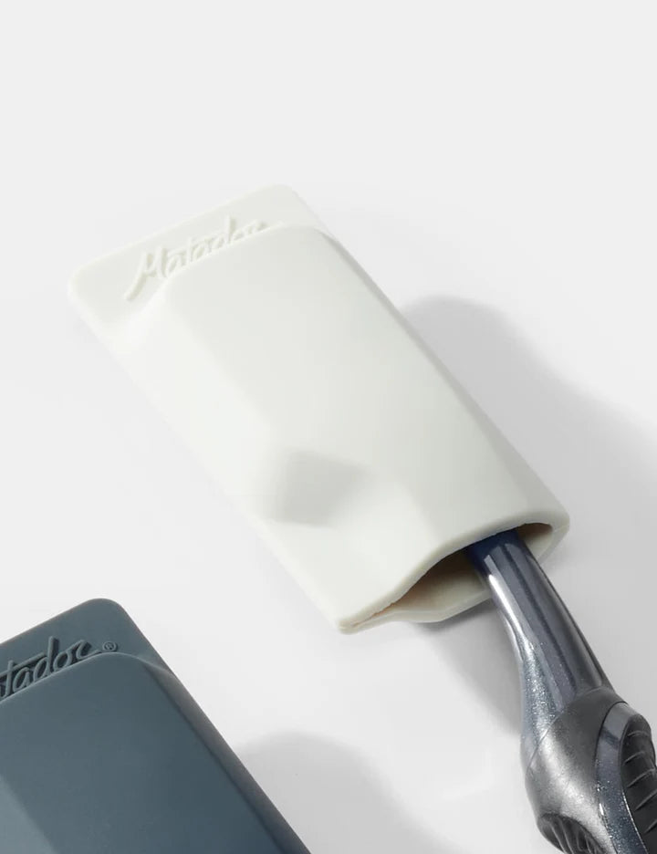White cylindrical object with a gray handle on a white background