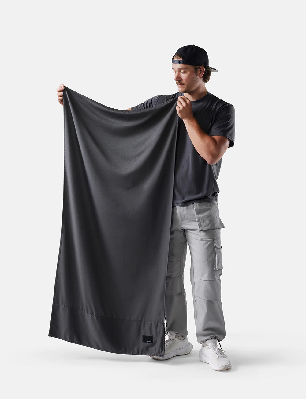 Man holding a large black fabric against a white background