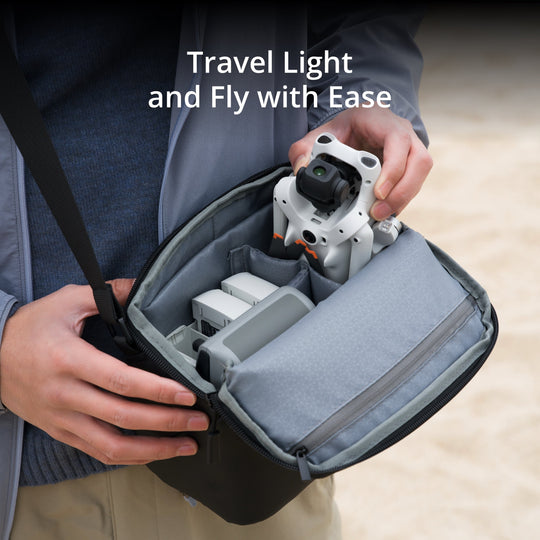 Person holding a compact drone bag with drone equipment inside, text 'Travel Light and Fly with Ease'.