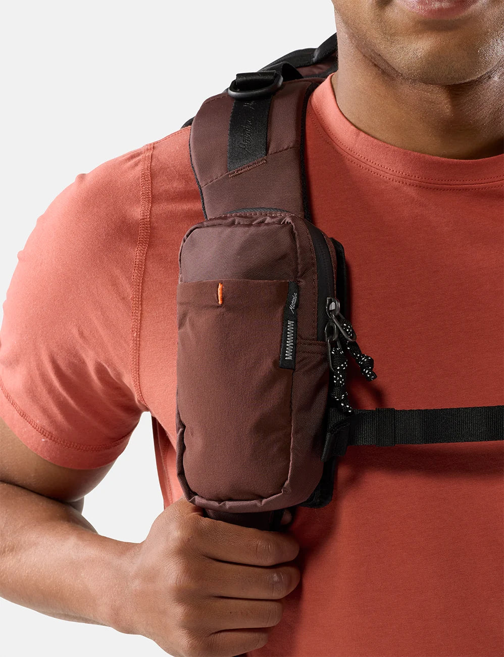 Person wearing a garnet matador speed stash pocket bag on a plain background