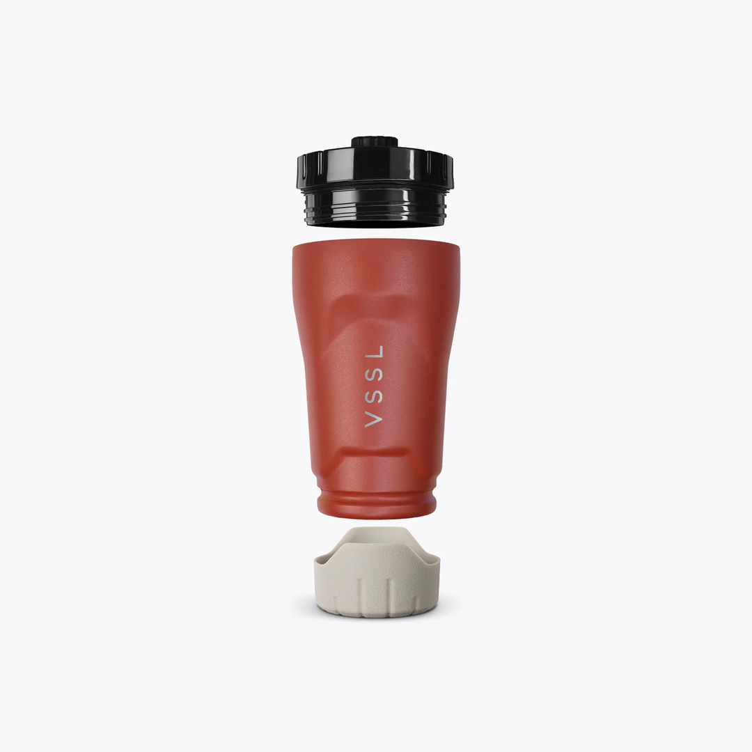Red travel mug with black lid and beige base on a white background