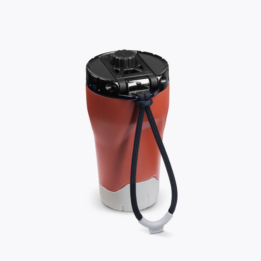 Red and gray travel mug with a black lid and handle on a white background